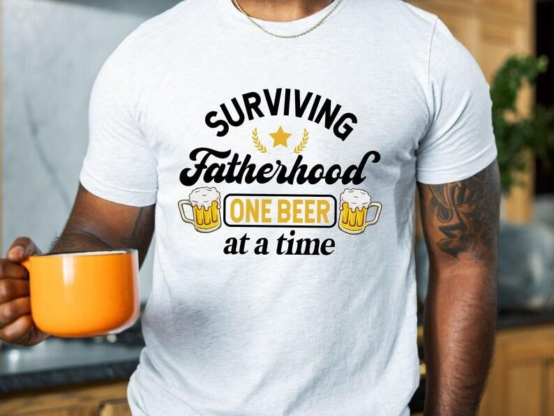 Surviving Fatherhood One Beer At A Time Shirt/T-shirt/Hoodie/Sweater, Funny Father Shirt, Husband Shirt, Fathers Day...