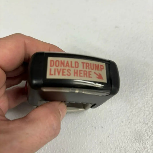 Donald Trump Lives Here Stamp - Black Design with Red Text, Ideal for Collecting and Displaying T-Shirts, Hoodie, Sweatshirt